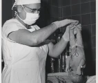 Virginia Apgar holds a newborn baby with clamped umbilicus cord