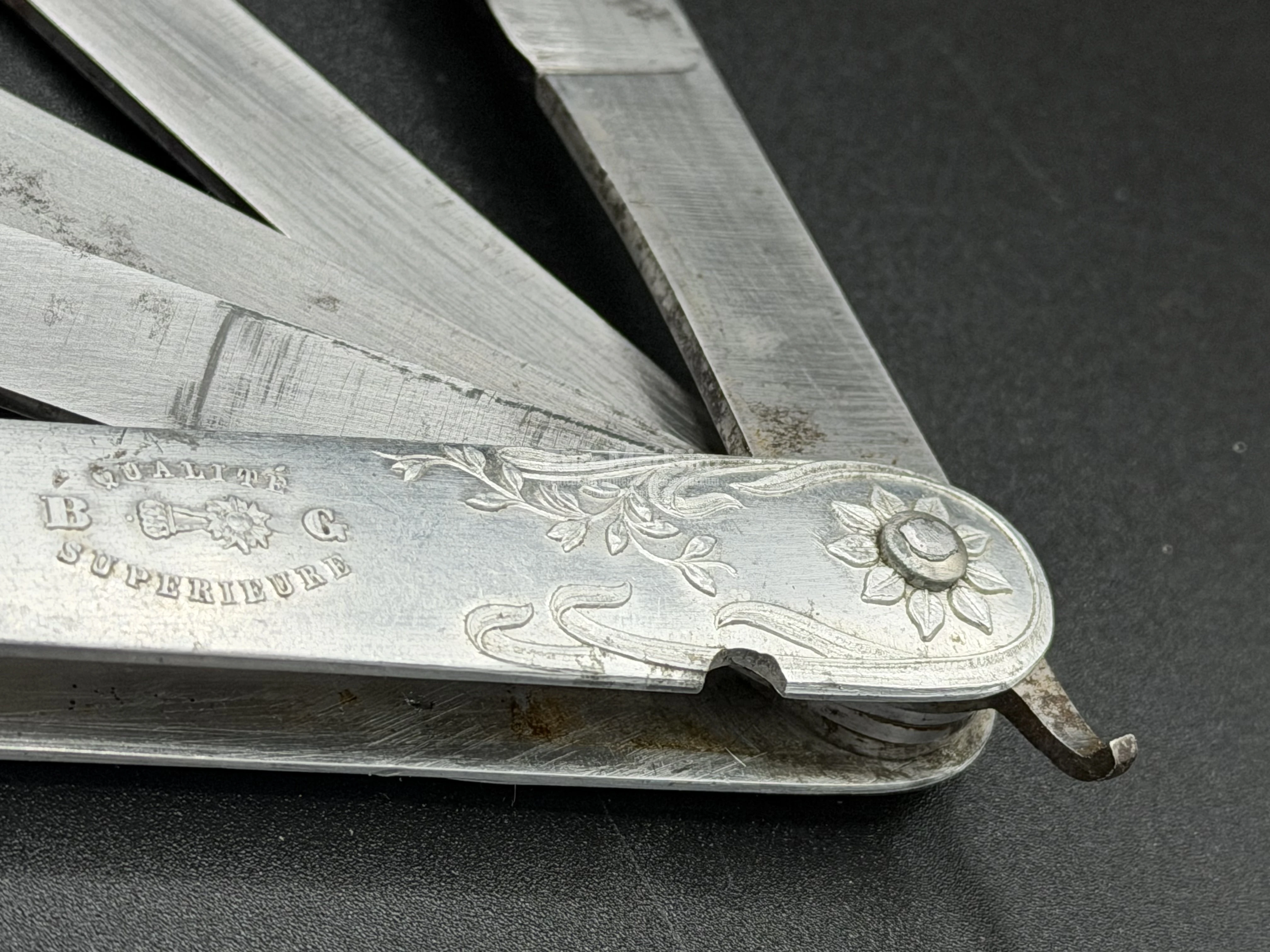 Floral ornament in style of Art Nouveau on the aluminium scale of the vintage French multi-bladed fleam.