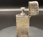 Hypodermic Pravaz syringe in a rich floral ornamented metal case with an inscription on the bottom "T.A.M. Ear & Throat Class. 1901"